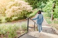 Girl walks along the path in the city park and looking at the blooming trees at spring time Royalty Free Stock Photo