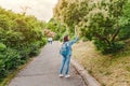 Girl walks along the path in the city park and looking at the blooming trees at spring time Royalty Free Stock Photo