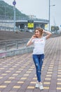 Hipster girl wearing blank white t-shirt, jeans and baseball cap posing against rough street wall, full length portrait, Royalty Free Stock Photo