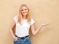 Hipster girl wearing blank white t-shirt and jeans posing against rough street wall, minimalist urban clothing style Royalty Free Stock Photo