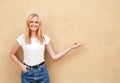 Hipster girl wearing blank white t-shirt and jeans posing against rough street wall, minimalist urban clothing style Royalty Free Stock Photo
