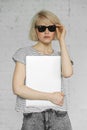 Hipster girl wears sunglasses and jeans holds laptop at daylight Royalty Free Stock Photo