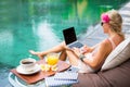 Girl working with computer by the pool