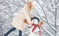 Hipster Girls friends playing with Snowman on snow Winter landscape. Christmas preparation - funny girls make snowman Royalty Free Stock Photo