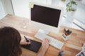 Hipster with graphics tablet at computer desk Royalty Free Stock Photo