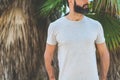 Hipster handsome male model with beard wearing gray blank t-shirt and a black snapback cap with space for your logo or Royalty Free Stock Photo