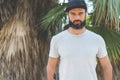 Hipster handsome male model with beard wearing gray blank t-shirt and a black snapback cap with space for your logo or