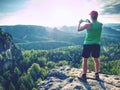 Hipster hiker. Amateur takes photos with smart phone