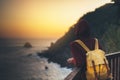 Hipster hiker tourist with backpack looking of amazing seascape sunset on background blue sea, girl enjoying ocean horizon, Royalty Free Stock Photo