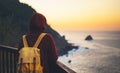 Hipster hiker tourist with backpack looking of amazing seascape sunset on background blue sea, girl enjoying ocean horizon, panora