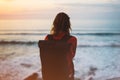 Hipster hiker tourist with backpack looking of amazing seascape sunset on background blue sea, photographer enjoying ocean horizon Royalty Free Stock Photo