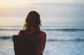 Hipster hiker tourist with backpack looking of amazing seascape sunset on background blue sea, photographer enjoying ocean horizon Royalty Free Stock Photo