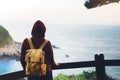 Hipster hiker tourist with backpack looking on seascape sunset, background blue sea and mountain, girl enjoying ocean horizon Royalty Free Stock Photo