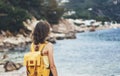 Hipster hiker tourist with backpack looking on seascape sunset, background blue sea and mountain, girl enjoying ocean horizon Royalty Free Stock Photo