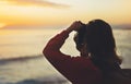 Hipster hiker tourist with backpack taking photo of amazing seascape sunset on camera on background blue sea, photographer enjoyin Royalty Free Stock Photo