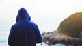 Hipster hiker tourist looking on seascape sunset, background blue sea and mountain Royalty Free Stock Photo