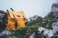 Hipster hiker tourist yellow backpack closeup on background green grass nature in mountain, blurred panoramic landscape, traveler Royalty Free Stock Photo