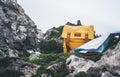 Hipster hiker tourist yellow backpack and map europe on background green grass nature in mountain, blurred panoramic landscape Royalty Free Stock Photo