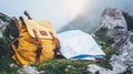 Hipster hiker tourist yellow backpack and map europe on background green grass nature in mountain, blurred panoramic landscape, tr