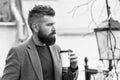 Hipster hold paper coffee cup and enjoy park environment. Relaxing coffee break. Drink it on the go. Man bearded hipster Royalty Free Stock Photo