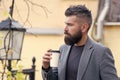 Hipster hold paper coffee cup and enjoy park environment. Relaxing coffee break. Drink it on the go. Man bearded hipster Royalty Free Stock Photo