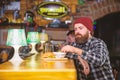 Hipster hungry man eat burger. Man with beard eat burger menu. Brutal hipster bearded man sit at bar counter. Cheat meal Royalty Free Stock Photo