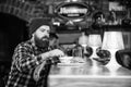 Hipster hungry man eat burger. Man with beard eat burger menu. Brutal hipster bearded man sit at bar counter. Cheat meal Royalty Free Stock Photo