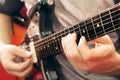 Casually dressed young man with guitar playing songs in the room at home. Online guitar lessons concept. Male guitarist practicing