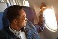 Hipster male traveller opening airplane window and watching outside landscape during beautiful sunrise Royalty Free Stock Photo