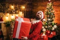 Hipster man, bearded Santa celebrate Thanksgiving day and Christmas. Santa man holding gift. Delivery gifts. Gift