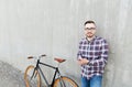 Hipster man in earphones with smartphone and bike Royalty Free Stock Photo