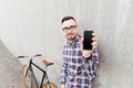 Hipster man in earphones with smartphone and bike Royalty Free Stock Photo