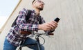 Hipster man in earphones with smartphone and bike Royalty Free Stock Photo