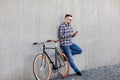 Hipster man in earphones with smartphone and bike Royalty Free Stock Photo