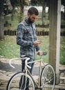 Hipster man with a fixie bike and smartphone Royalty Free Stock Photo