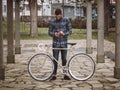 Hipster man with a fixie bike and smartphone Royalty Free Stock Photo