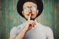 Hipster man gesture for silence showing hush sign Royalty Free Stock Photo