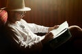 Hipster man in glasses reading looking at map sitting on couch i Royalty Free Stock Photo