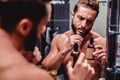 Hipster man holding bottle in the bathroom Royalty Free Stock Photo