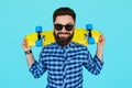 Hipster man holding a bright vibrant yellow skateboard