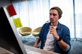 Hipster man holding glasses while working at computer desk Royalty Free Stock Photo