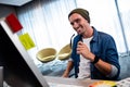 Hipster man holding glasses while working at computer desk Royalty Free Stock Photo