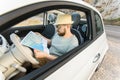 Hipster man looking on location navigation map in car, tourist traveler driving and hold in male hands europe Royalty Free Stock Photo