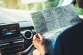 Hipster man looking and point finger on location navigation map in car, tourist traveler driving and hold in male hands europe car Royalty Free Stock Photo