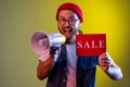 Hipster man paying attention announcing big sale yelling at loudspeaker black Friday shopping. Royalty Free Stock Photo