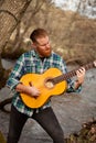 Hipster man with red beard with a guitar in the field Royalty Free Stock Photo