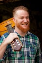 Hipster man with red beard with a guitar Royalty Free Stock Photo