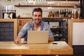 Hipster man smiling at camera while using laptop Royalty Free Stock Photo