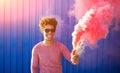 Hipster man smiling and holding a pink smoke bomb Royalty Free Stock Photo