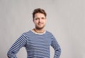 Hipster man in striped t-shirt, gray background, studio shot